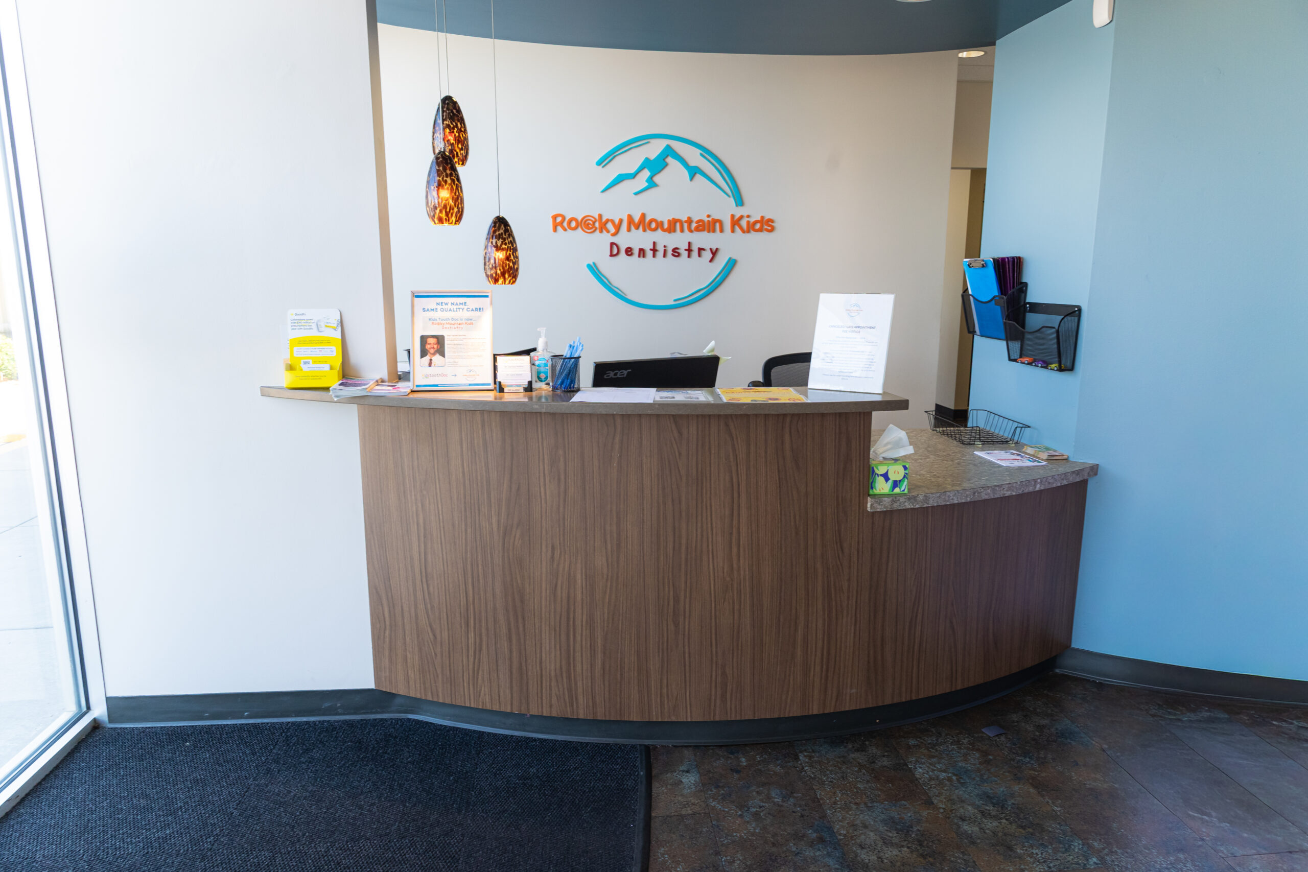 Rocky Mountain Kids Dentistry reception desk with logo and welcome area in Englewood.