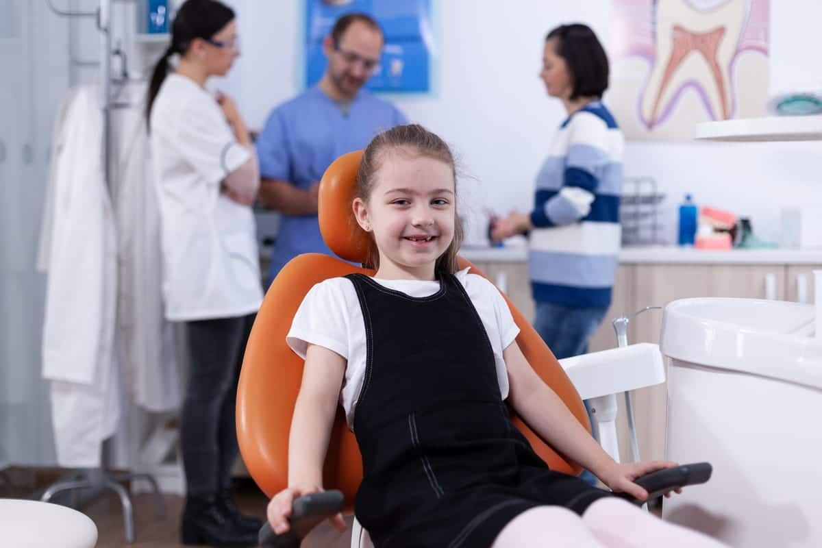 Young patient smiling in dental chair during routine checkup at Englewood dental office.